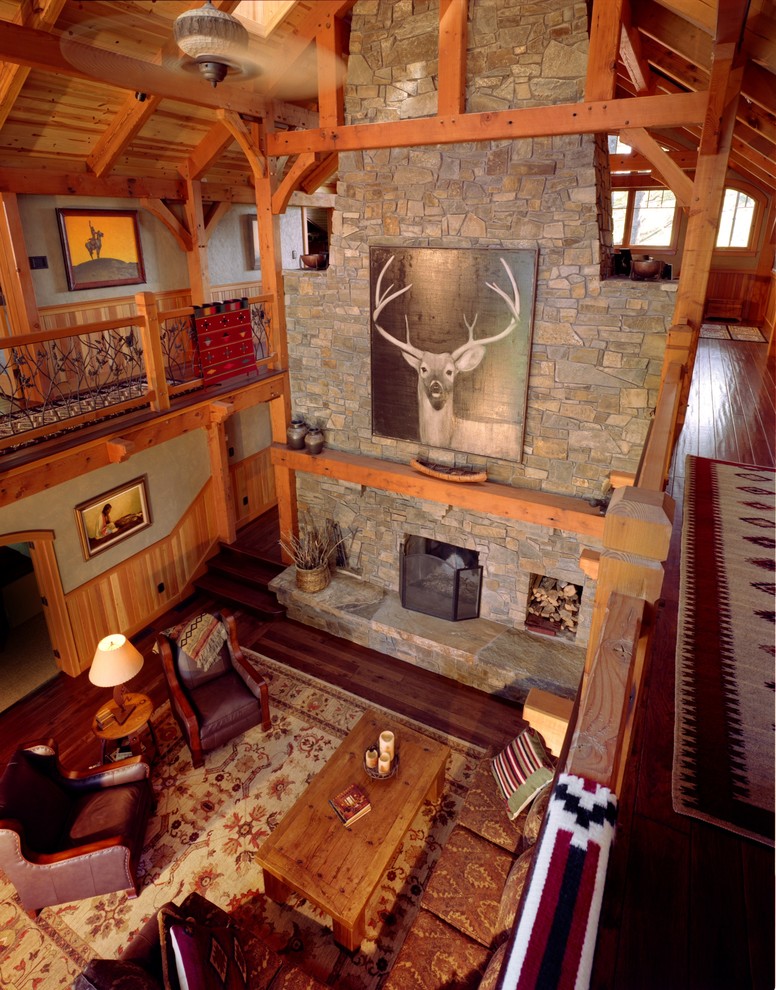 Foto de salón tipo loft rústico grande con paredes beige, suelo de madera oscura, todas las chimeneas y marco de chimenea de piedra