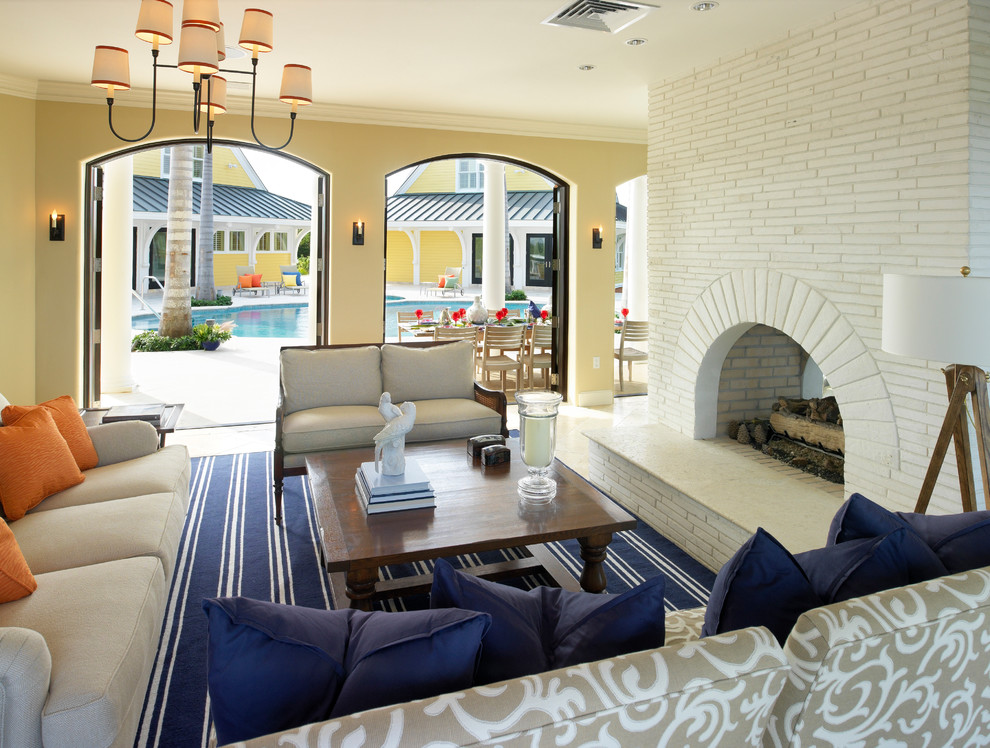 World-inspired living room in Boston with yellow walls, a two-sided fireplace, a brick fireplace surround and feature lighting.