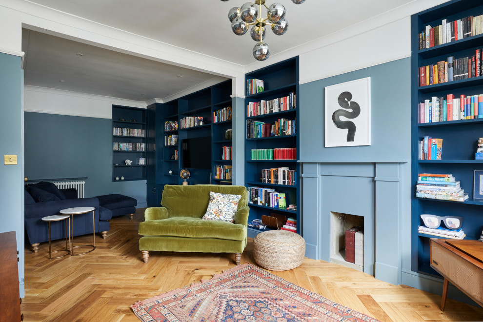 Kleine, Abgetrennte Klassische Bibliothek mit blauer Wandfarbe, braunem Holzboden, Kamin, verputzter Kaminumrandung, TV-Wand und braunem Boden in London
