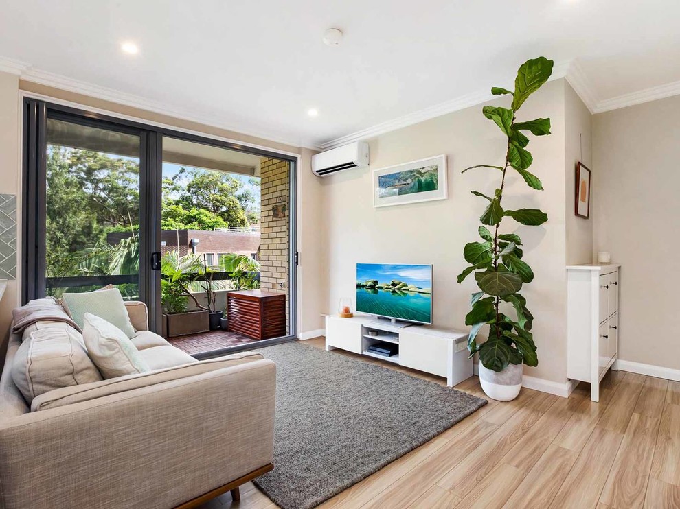 Mittelgroßes, Offenes Modernes Wohnzimmer ohne Kamin mit beiger Wandfarbe, Laminat, freistehendem TV und beigem Boden in Sydney