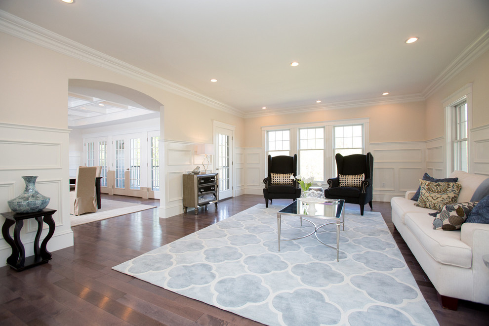 Idee per un soggiorno tradizionale con pareti beige e pavimento in legno massello medio