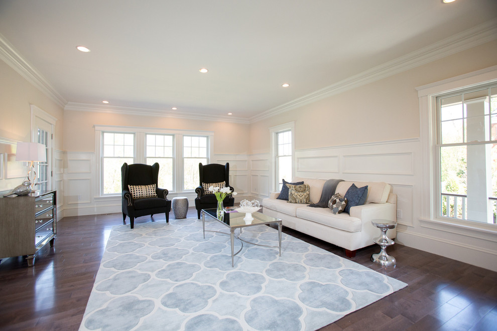 Idee per un soggiorno chic con pareti beige e pavimento in legno massello medio