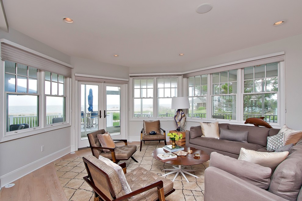 Geräumiges, Offenes Maritimes Wohnzimmer mit weißer Wandfarbe, hellem Holzboden und Eckkamin in New York