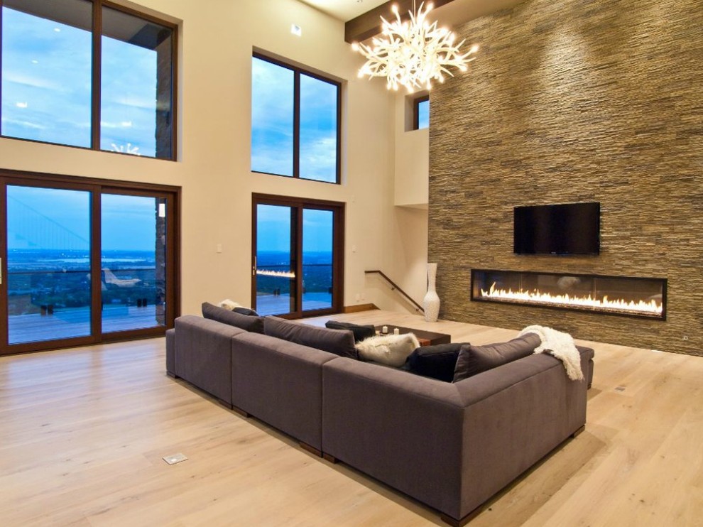 Пример оригинального дизайна: изолированная гостиная комната в современном стиле с горизонтальным камином, телевизором на стене и бежевым полом