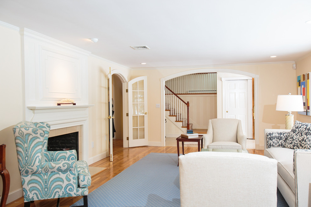 Идея дизайна: гостиная комната в классическом стиле с бежевыми стенами, паркетным полом среднего тона, стандартным камином и фасадом камина из дерева