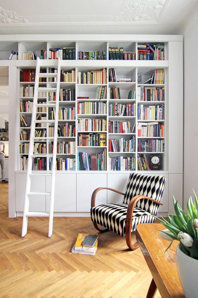 На фото: изолированная гостиная комната среднего размера в классическом стиле с с книжными шкафами и полками, серыми стенами и светлым паркетным полом без камина, телевизора с