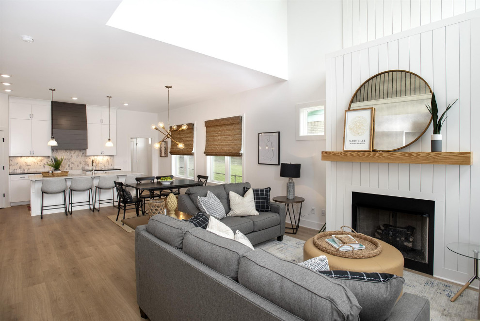 Exemple d'un grand salon tendance ouvert avec un mur blanc, une cheminée standard et un sol marron.