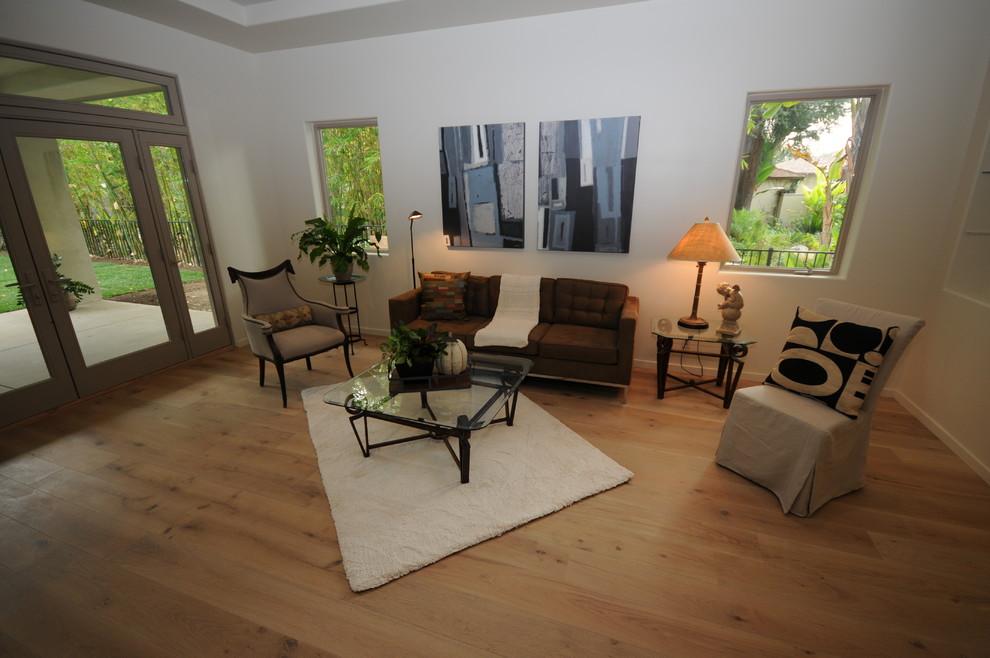 Mittelgroßes, Repräsentatives, Fernseherloses, Abgetrenntes Modernes Wohnzimmer ohne Kamin mit hellem Holzboden und beiger Wandfarbe in Los Angeles