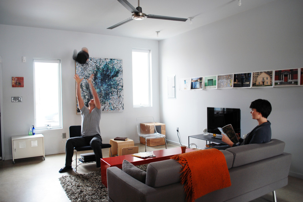 Стильный дизайн: гостиная комната в стиле модернизм с бетонным полом и ковром на полу - последний тренд
