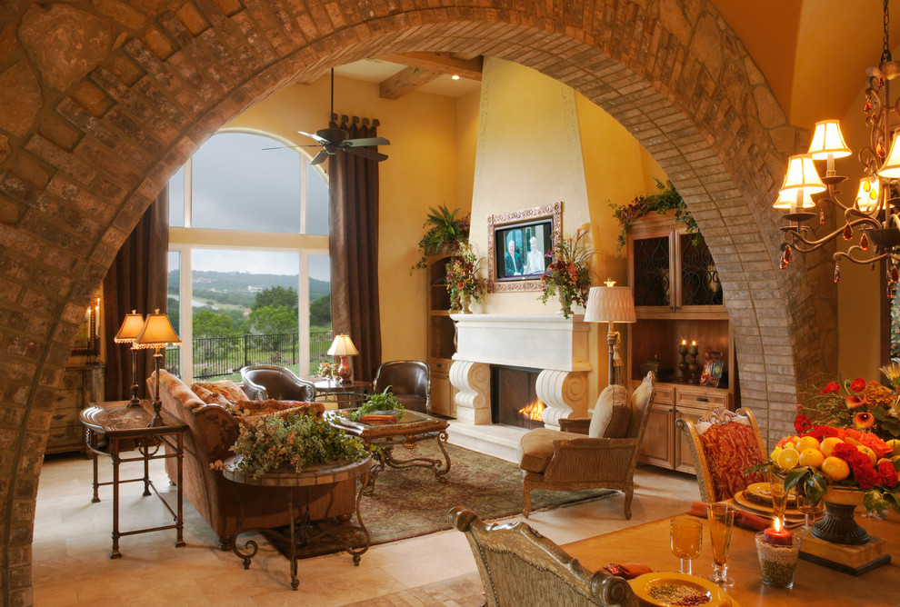 Идея дизайна: большая гостиная комната в средиземноморском стиле с стандартным камином и красивыми шторами