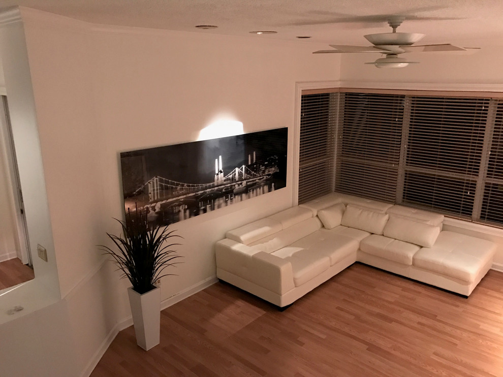 Cette image montre un grand salon design ouvert avec un mur blanc, parquet clair et aucune cheminée.