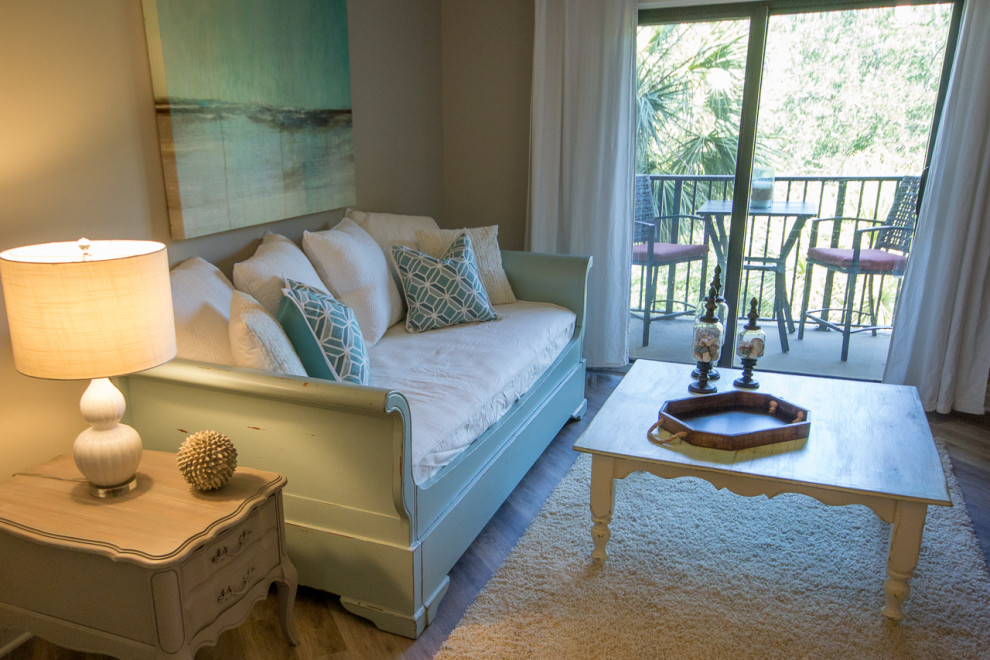 Foto di un piccolo soggiorno stile marinaro aperto con pareti beige, pavimento in vinile, TV autoportante e pavimento marrone