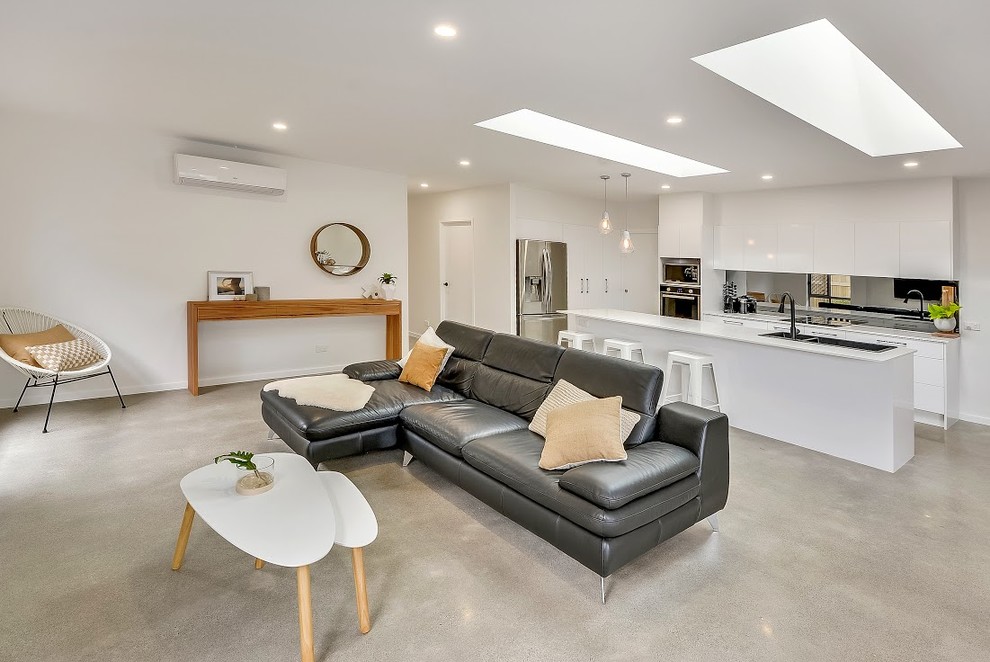 Mittelgroßes, Offenes Modernes Wohnzimmer mit weißer Wandfarbe, Betonboden und TV-Wand in Sunshine Coast