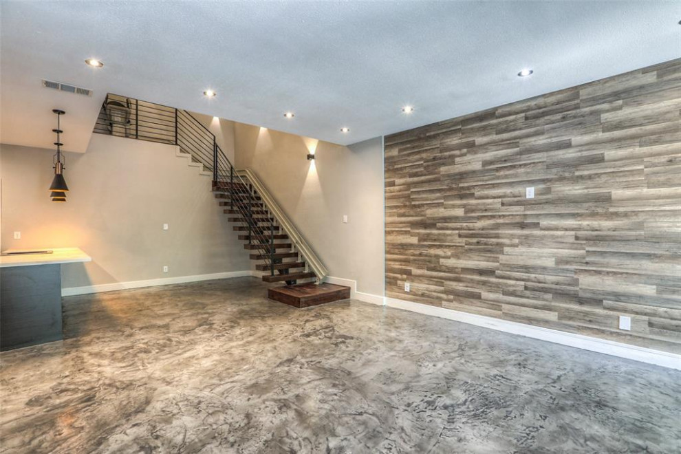 Foto de salón abierto actual de tamaño medio con suelo de cemento, estufa de leña, marco de chimenea de baldosas y/o azulejos, suelo gris y madera