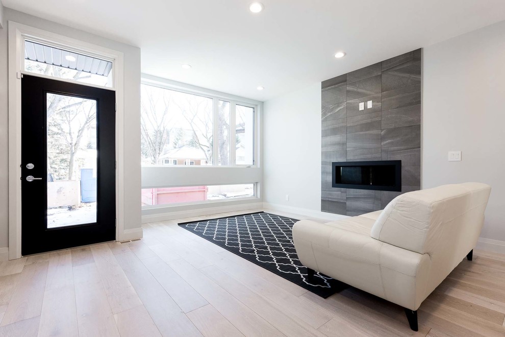 Medium sized contemporary formal open plan living room in Edmonton with white walls, light hardwood flooring, a ribbon fireplace and a tiled fireplace surround.