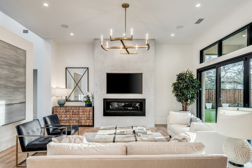 Offenes Modernes Wohnzimmer mit weißer Wandfarbe, hellem Holzboden, Kamin, verputzter Kaminumrandung, TV-Wand und braunem Boden in Dallas