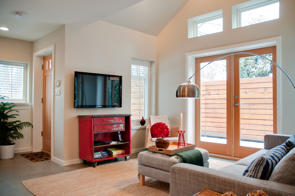 Foto på ett mellanstort funkis vardagsrum, med beige väggar och en väggmonterad TV