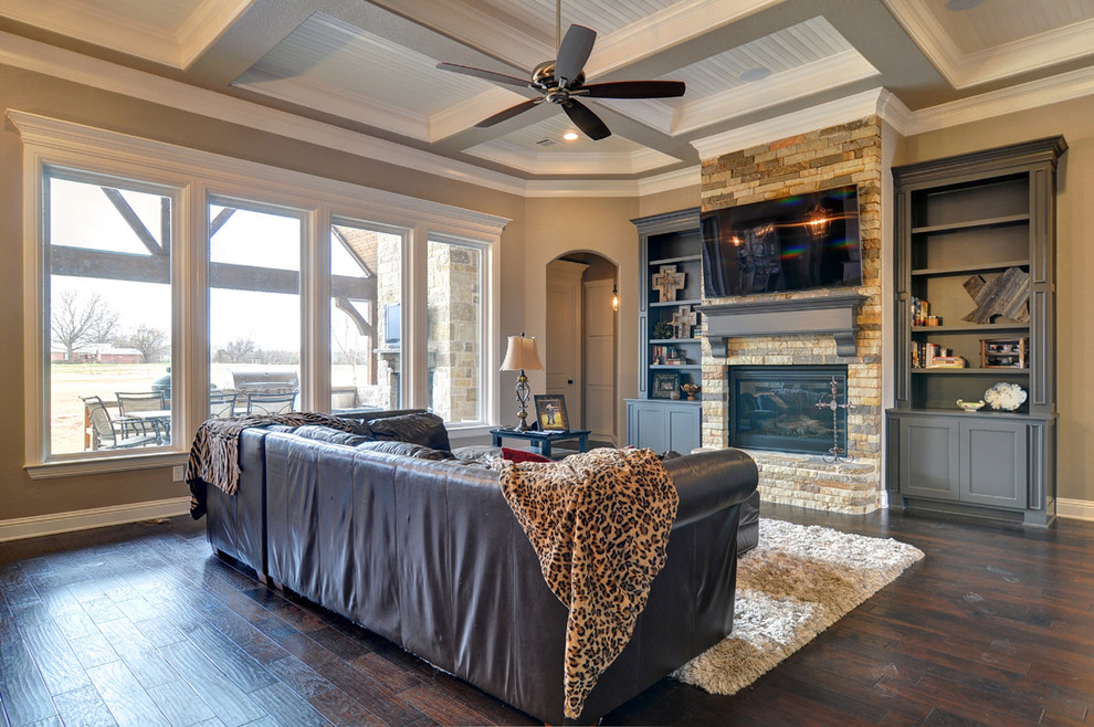 Großes, Offenes Klassisches Wohnzimmer mit beiger Wandfarbe, braunem Holzboden, Kamin und Kaminumrandung aus Stein in Dallas