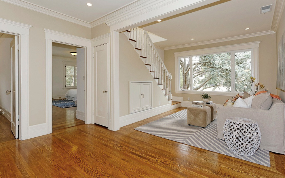 Immagine di un soggiorno minimal di medie dimensioni e chiuso con pareti beige e pavimento in legno massello medio