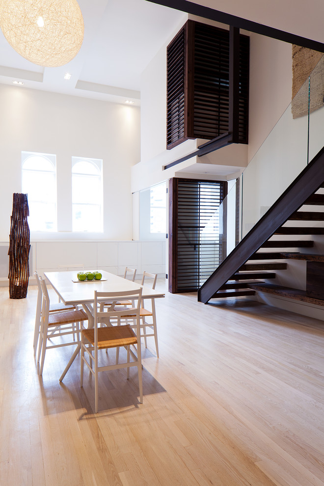 Ejemplo de salón tipo loft minimalista de tamaño medio sin chimenea y televisor con paredes blancas y suelo de madera clara