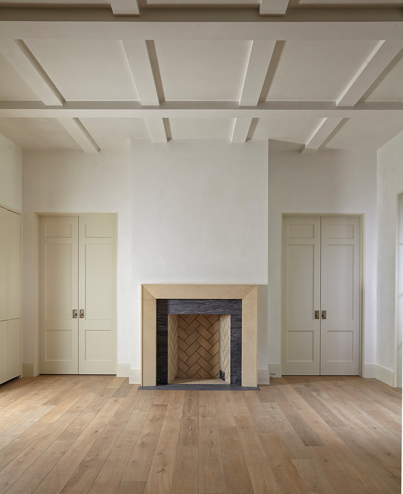Ejemplo de salón abierto minimalista grande con paredes blancas, suelo de madera clara, suelo marrón, estufa de leña y marco de chimenea de madera