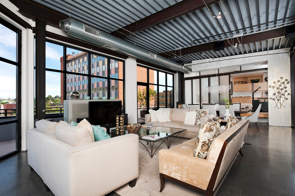 Offenes, Repräsentatives Industrial Wohnzimmer mit freistehendem TV und Betonboden in Denver