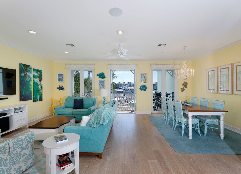 Идея дизайна: парадная, открытая гостиная комната среднего размера в морском стиле с желтыми стенами, светлым паркетным полом, телевизором на стене и бежевым полом без камина