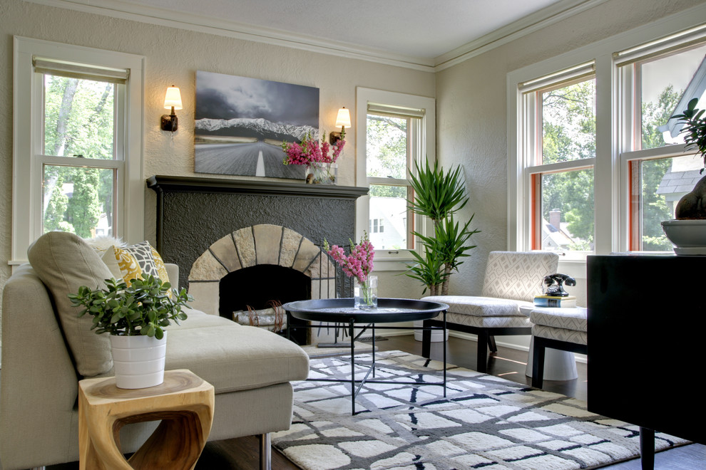 Immagine di un soggiorno minimal con pareti beige e camino classico