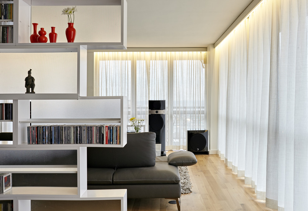 Foto de salón para visitas abierto escandinavo grande con paredes beige, suelo de madera clara y televisor independiente