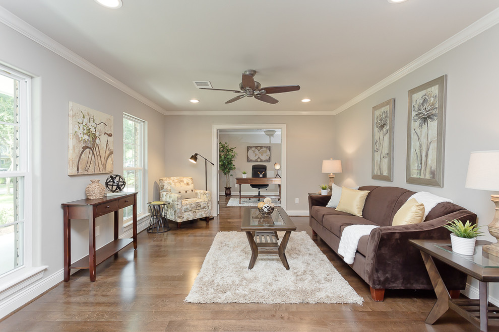 Стильный дизайн: гостиная комната в классическом стиле с серыми стенами, паркетным полом среднего тона, коричневым диваном и ковром на полу - последний тренд
