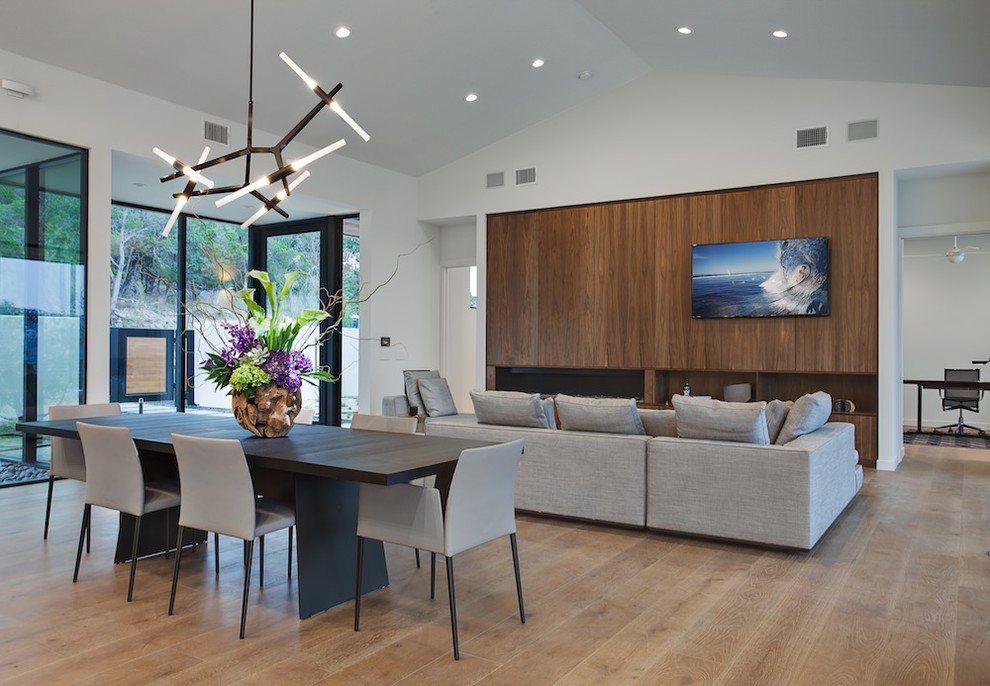 Photo of a contemporary open plan living room in Austin with white walls, medium hardwood flooring, a ribbon fireplace, a wooden fireplace surround and a wall mounted tv.