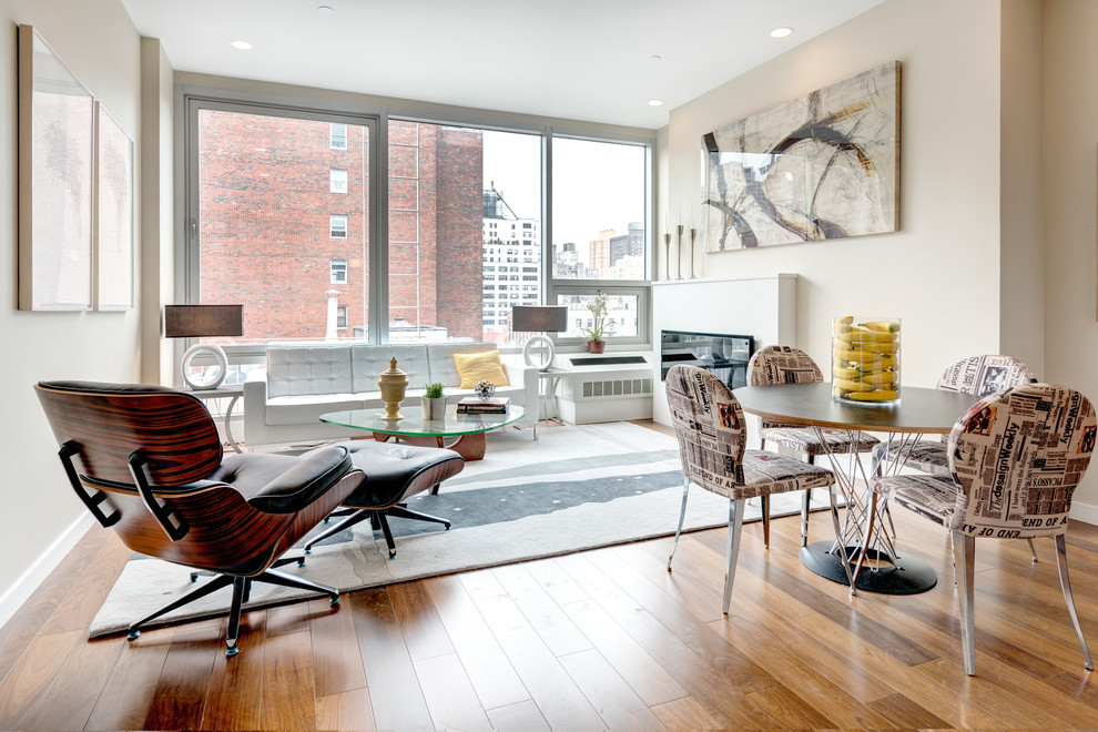 Mittelgroßes, Abgetrenntes Modernes Wohnzimmer ohne Kamin mit beiger Wandfarbe, braunem Holzboden und TV-Wand in New York