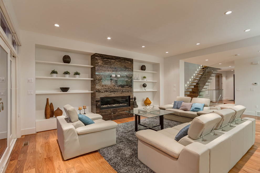 Inspiration for a medium sized modern open plan living room in Calgary with white walls, medium hardwood flooring, a standard fireplace and a stone fireplace surround.