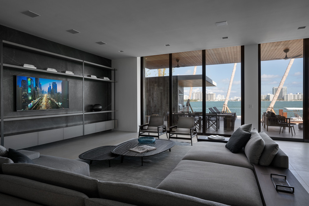 Großes, Offenes Modernes Wohnzimmer ohne Kamin mit weißer Wandfarbe, Betonboden, TV-Wand und grauem Boden in Miami
