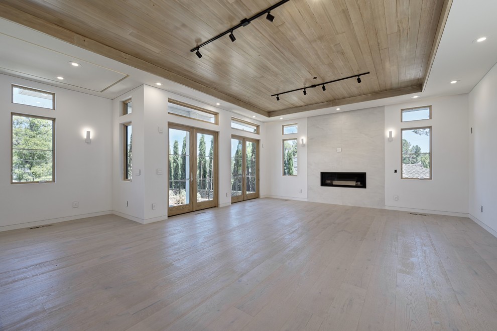 This is an example of a medium sized classic formal open plan living room in San Francisco with white walls, light hardwood flooring, a ribbon fireplace, a tiled fireplace surround and beige floors.