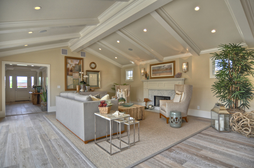 Example of a beach style gray floor living room design in Los Angeles with beige walls, a standard fireplace and no tv