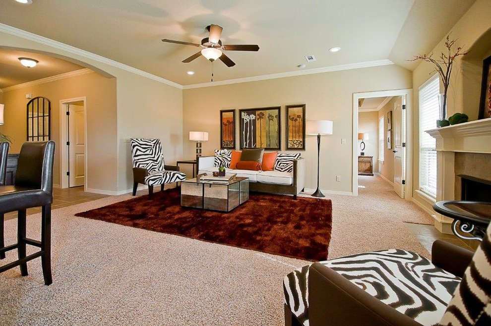 Offenes Klassisches Wohnzimmer mit beiger Wandfarbe, Teppichboden, Kamin, gefliester Kaminumrandung und TV-Wand in Sonstige