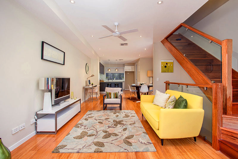 This is an example of a small modern open plan living room in Brisbane with beige walls, light hardwood flooring, no fireplace and a freestanding tv.