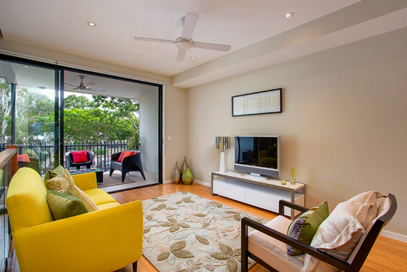 Imagen de salón abierto moderno pequeño sin chimenea con paredes beige, suelo de madera clara y televisor independiente
