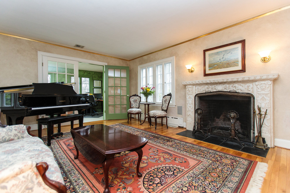 Großes, Offenes Klassisches Musikzimmer mit beiger Wandfarbe, braunem Holzboden, Kamin und Kaminumrandung aus Stein in Boston