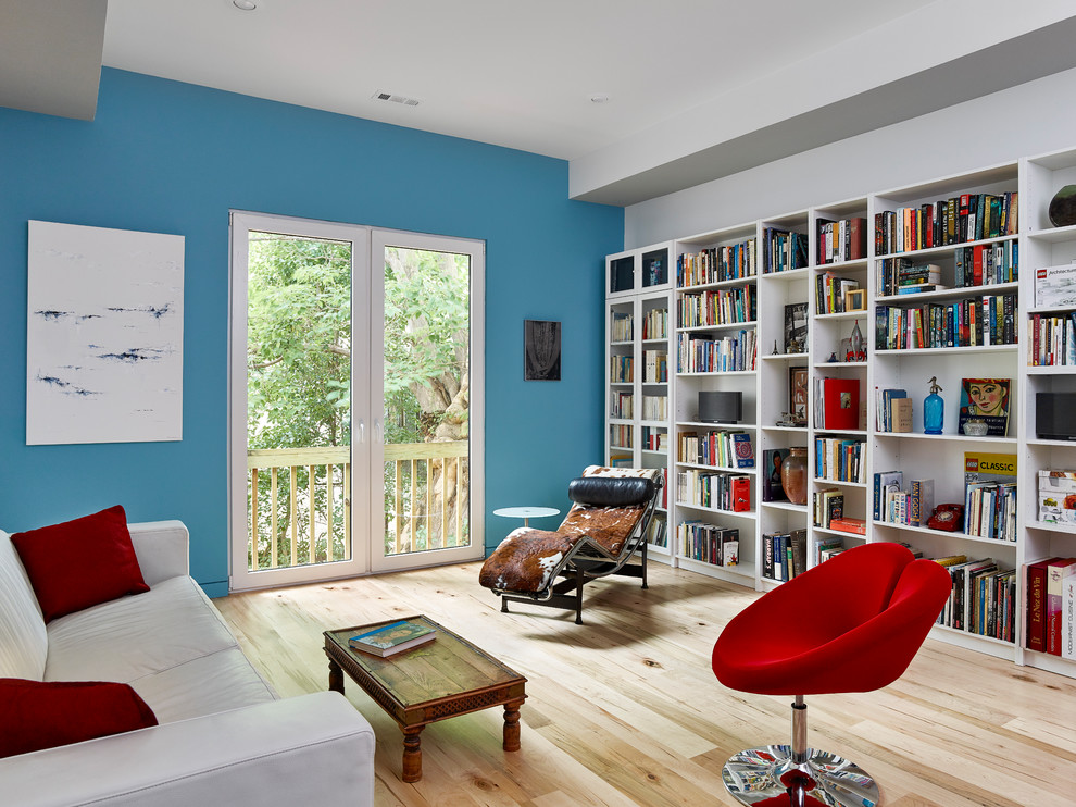 Ejemplo de salón abierto actual grande sin chimenea y televisor con paredes azules y suelo de madera clara