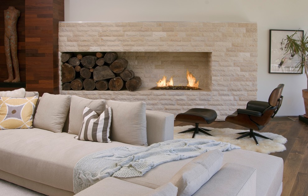 Photo of a modern living room in Los Angeles with a stone fireplace surround.