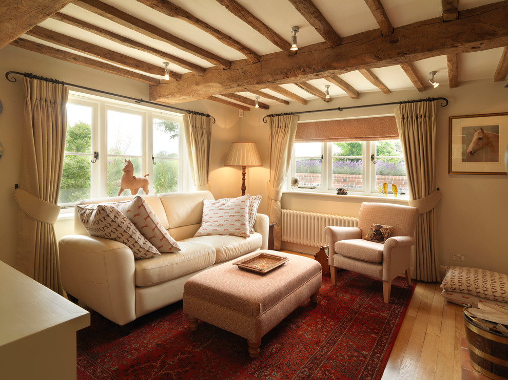 Kleine, Abgetrennte Country Bibliothek mit beiger Wandfarbe, braunem Holzboden und TV-Wand in Hampshire