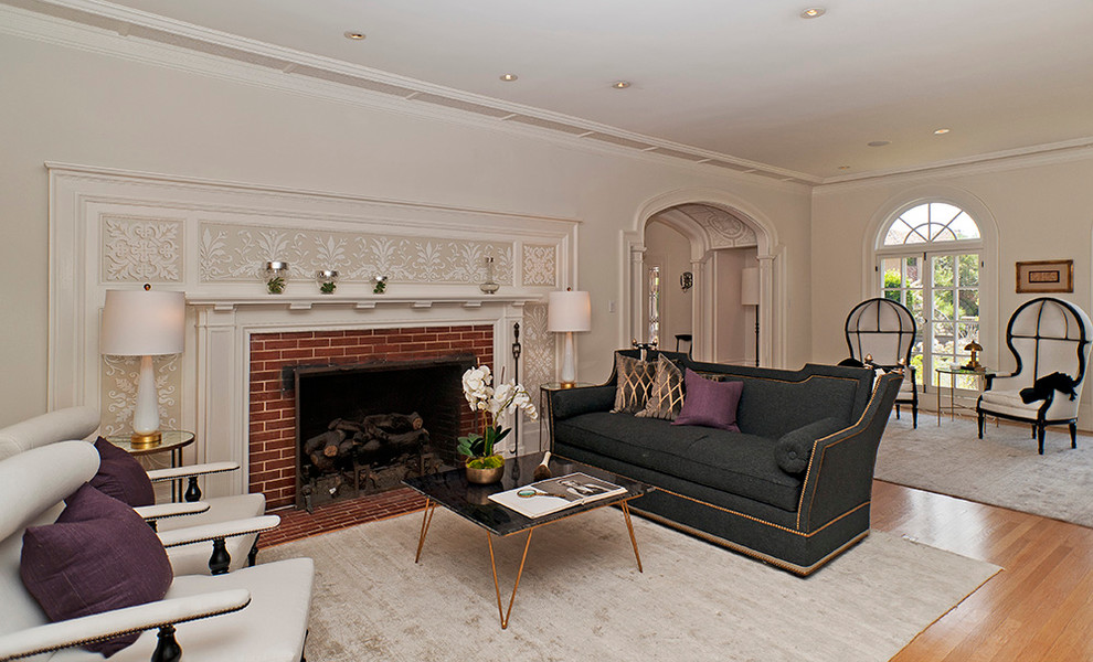 Стильный дизайн: гостиная комната в классическом стиле с фасадом камина из кирпича - последний тренд