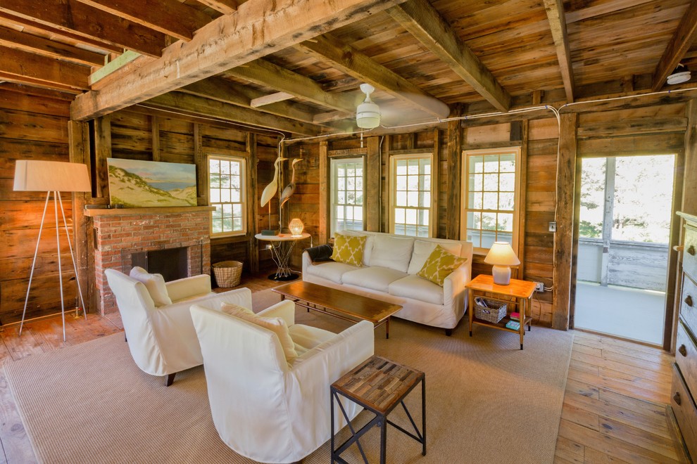 Rustikales Wohnzimmer mit beiger Wandfarbe, braunem Holzboden, Kamin und Kaminumrandung aus Holz in Boston