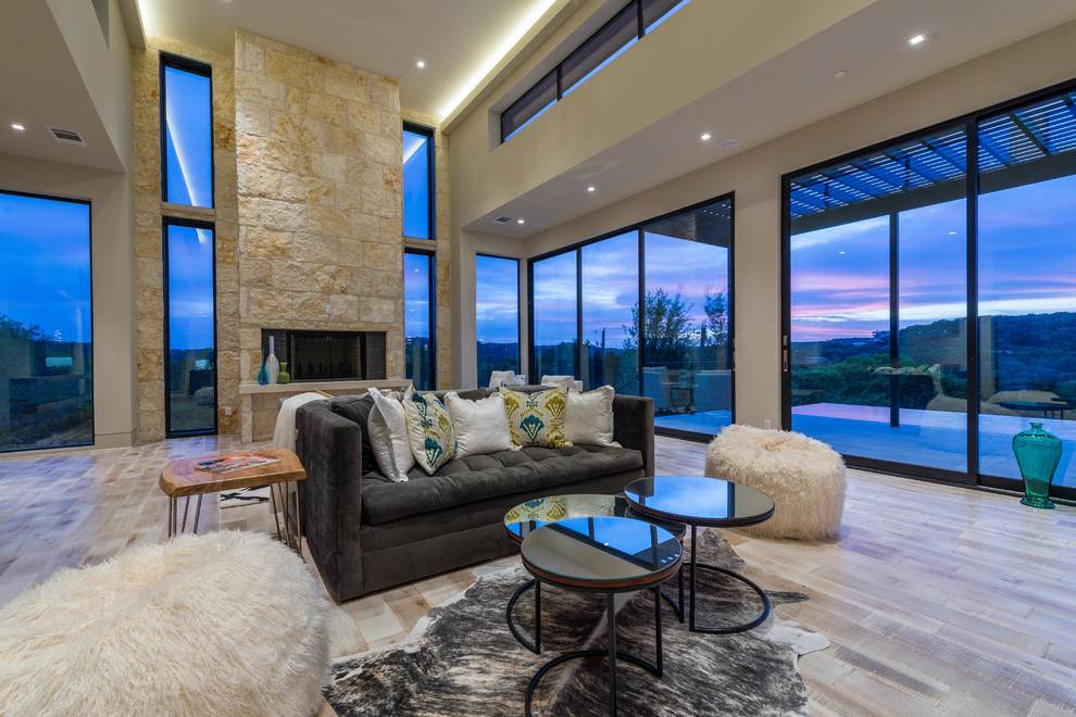 Inspiration for a contemporary formal open plan living room in Austin with beige walls, light hardwood flooring, a ribbon fireplace and a stone fireplace surround.