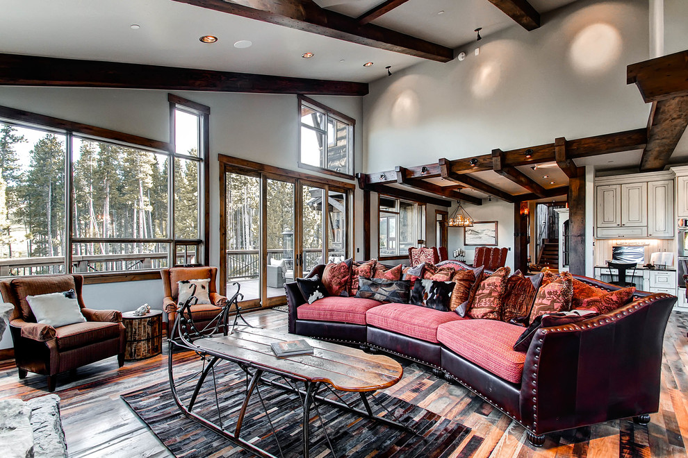 Example of a mountain style dark wood floor living room design in Denver with gray walls, a standard fireplace and a stone fireplace