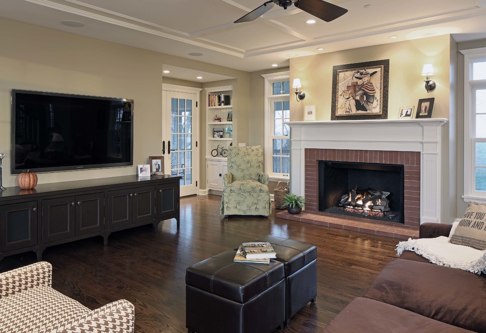 Example of a mid-sized country enclosed dark wood floor living room design in Omaha with beige walls, a standard fireplace, a brick fireplace and a wall-mounted tv