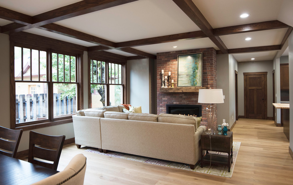 Living room - large craftsman formal and open concept light wood floor living room idea in Albuquerque with beige walls, a standard fireplace, a brick fireplace and a wall-mounted tv