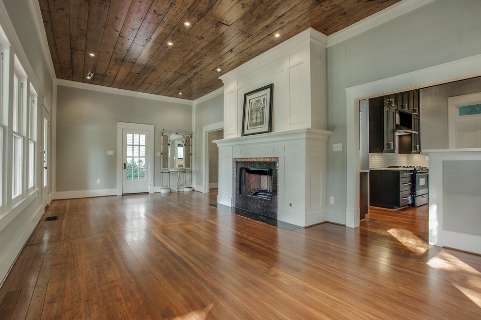 Example of a mid-sized arts and crafts open concept and formal medium tone wood floor living room design in Dallas with gray walls, a standard fireplace, a stone fireplace and no tv